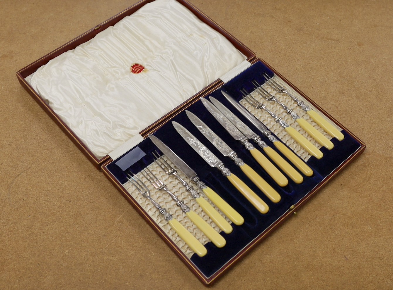 A cased set of six pairs of ivorine handled plated dessert eaters